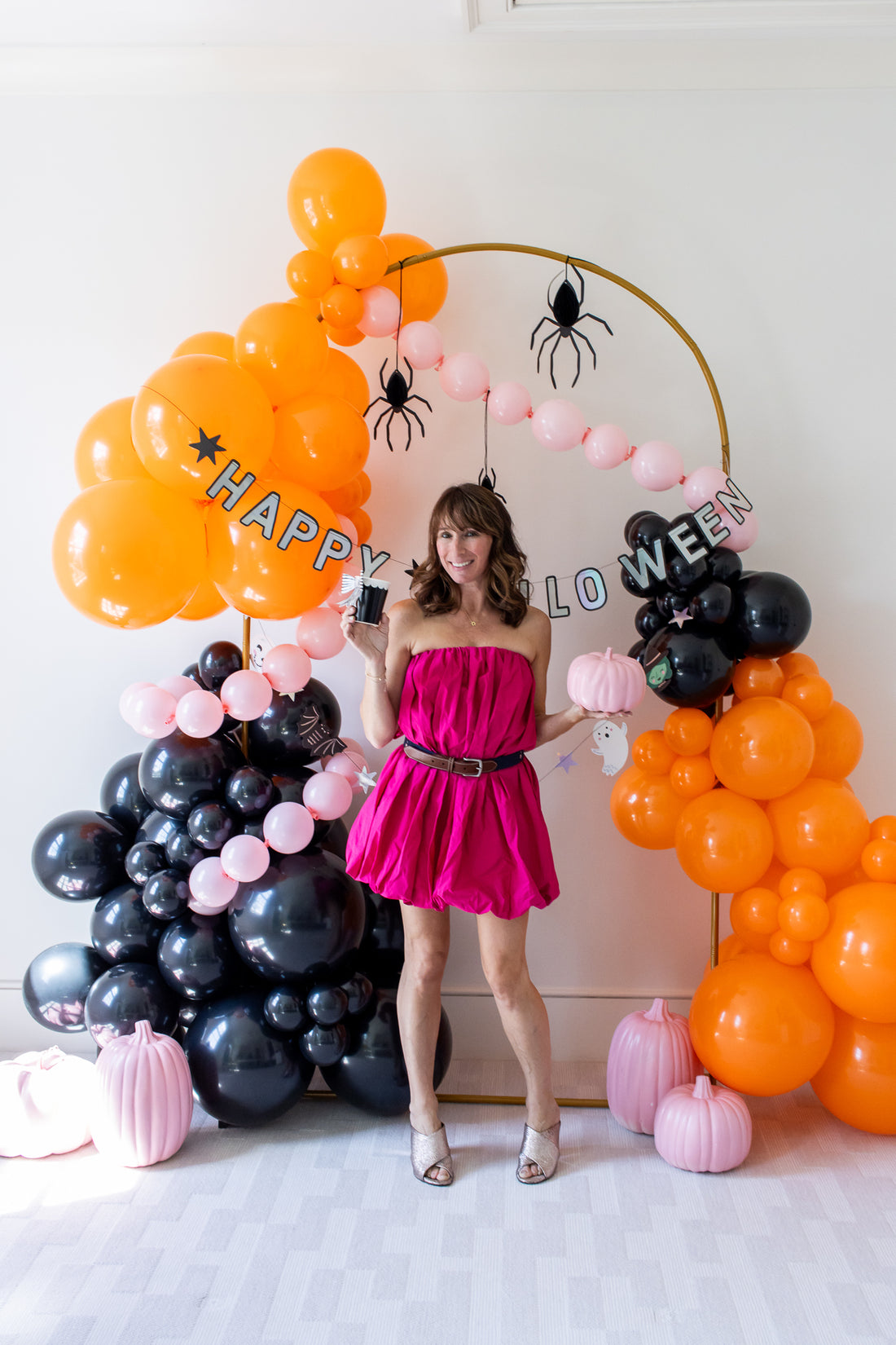 Halloween ballons and pumpkins with model in pink dress