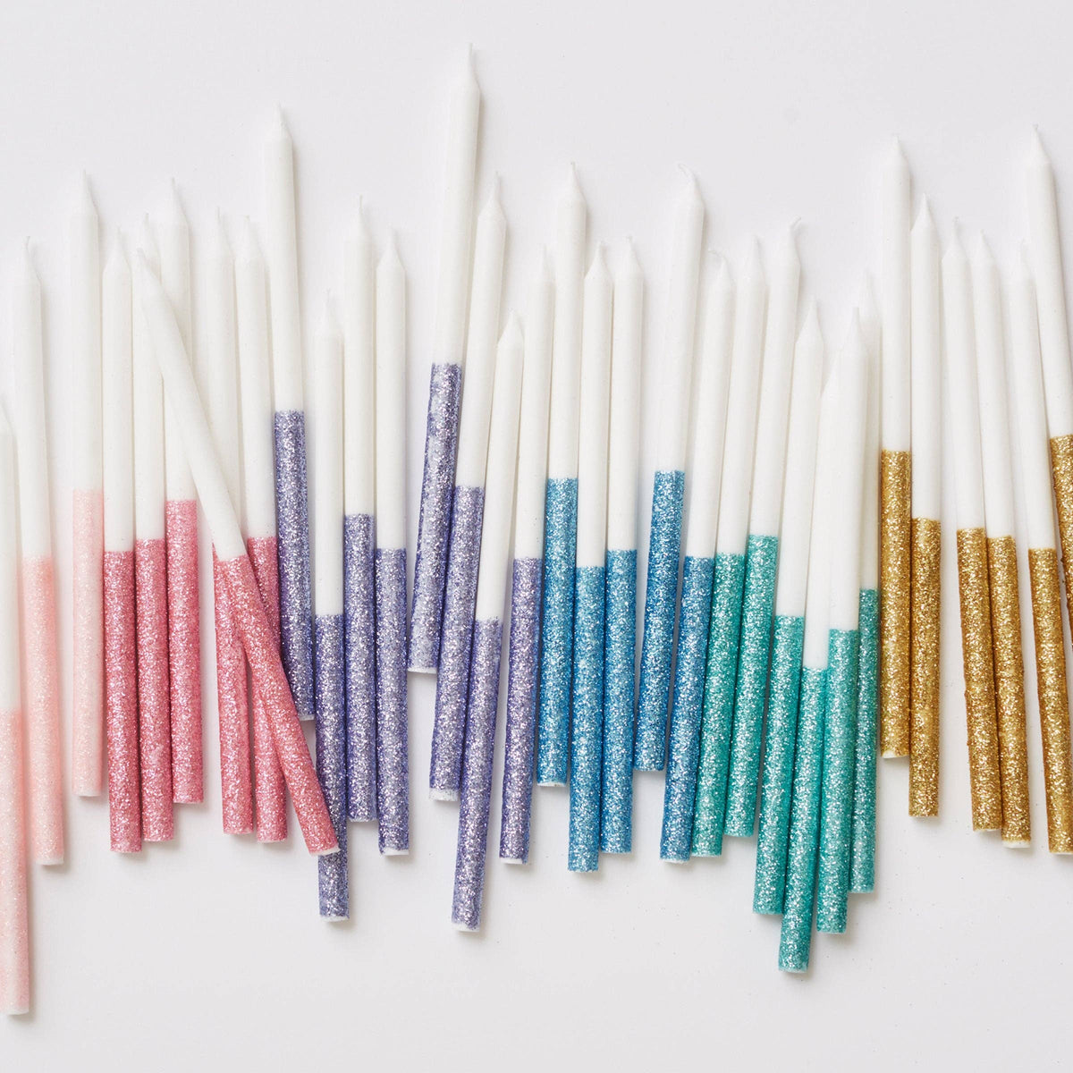 Glitter dipped candles in several colors spread out together